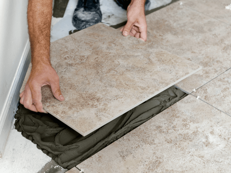 Man legt vloertegel op mortel